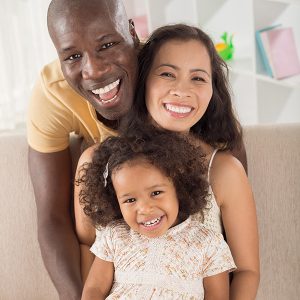 Vertical portrait of a mixed cheerful family posing at camera
